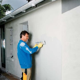 Udvendig isolering: Den indfarvede slutpuds trækkes på den hårde grundpuds Udvendig isolering: Den indfarvede slutpuds trækkes på den hårde grundpuds med stålbræt